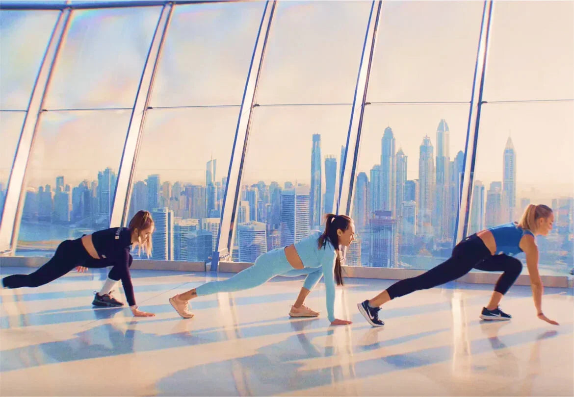 Women stretching in Dubai skyscraper gym with city skyline view