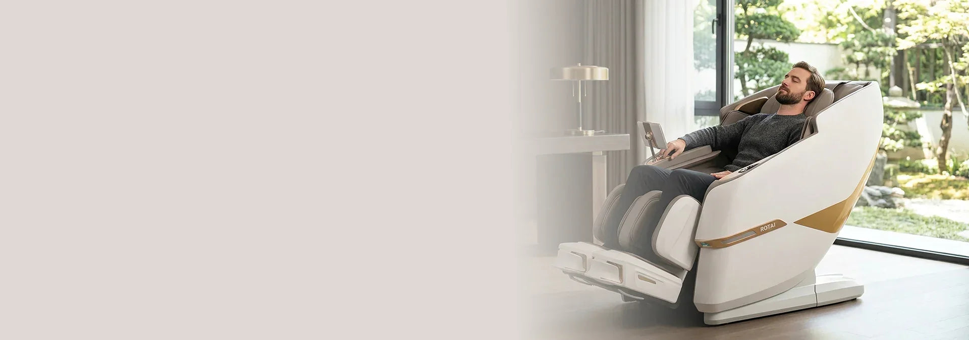 Man relaxing in modern full body massage chair in a bright living room with garden view