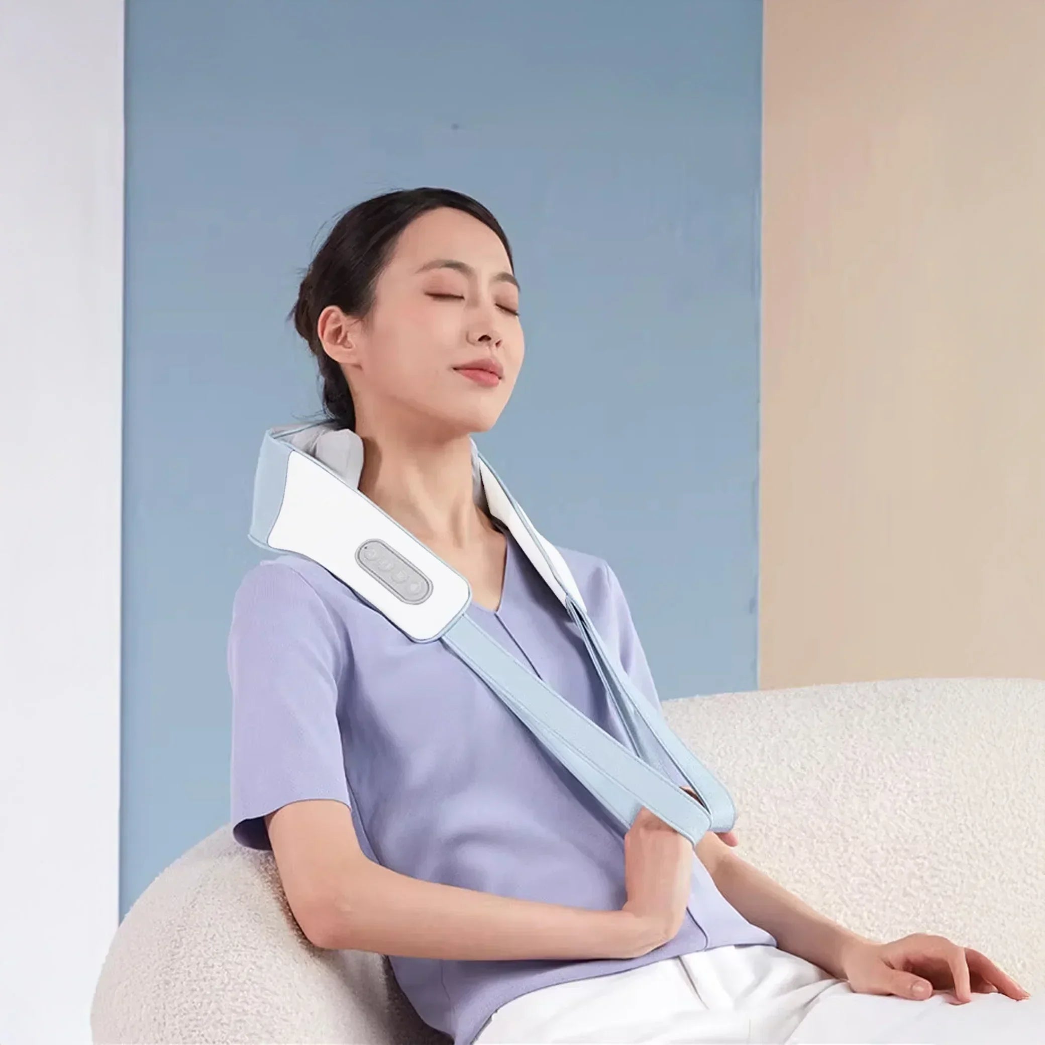 Woman relaxing with K35 Pro neck massager on sofa in modern indoor setting
