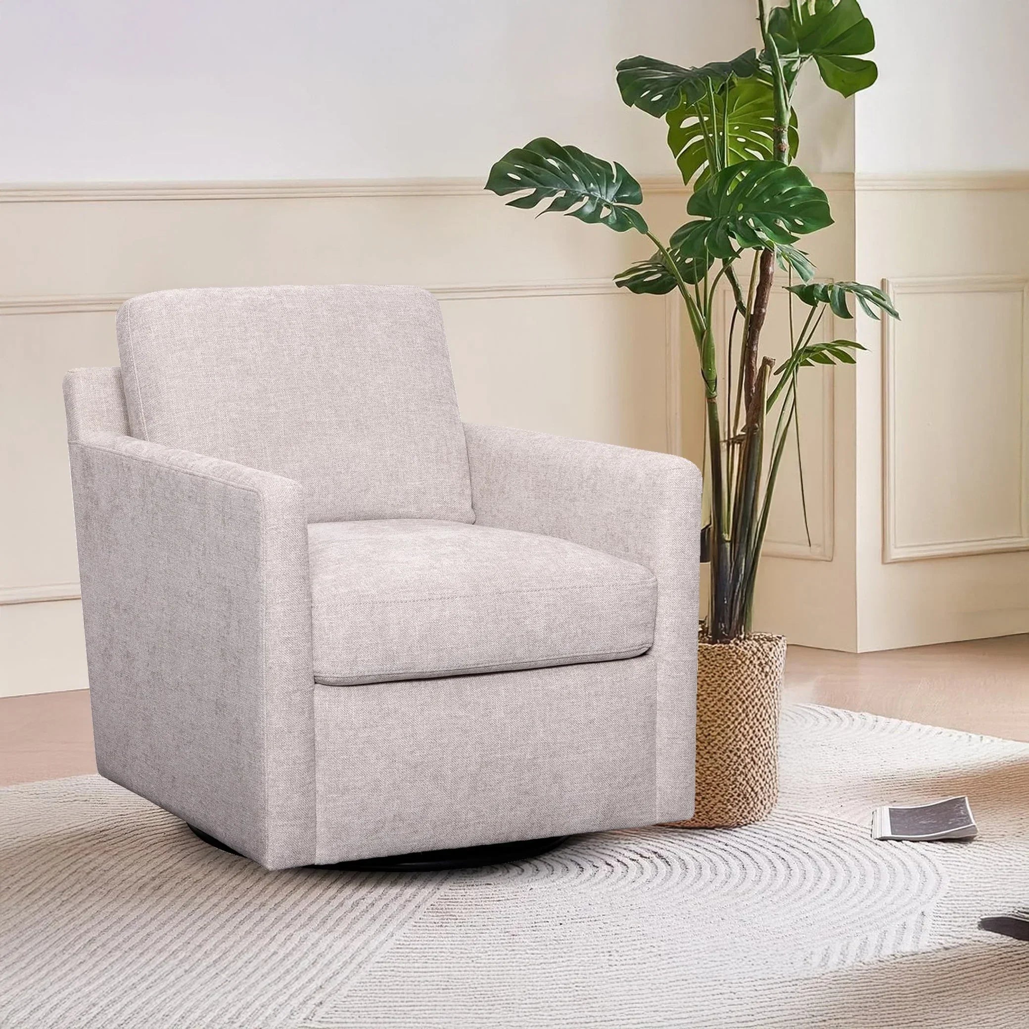 Light grey upholstered swivel accent chair in modern living room with indoor plant.