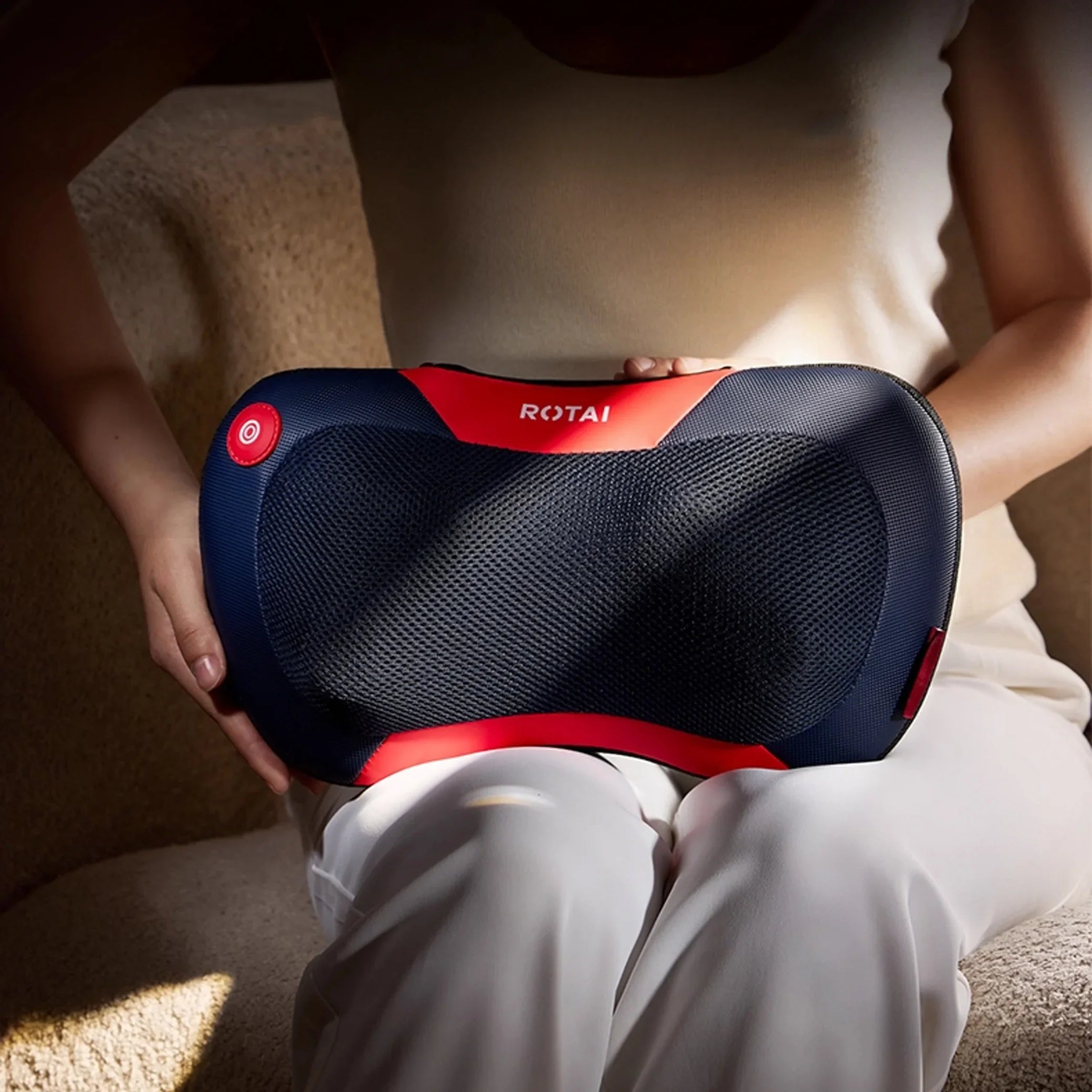Person using a Rotai massage pillow on their back