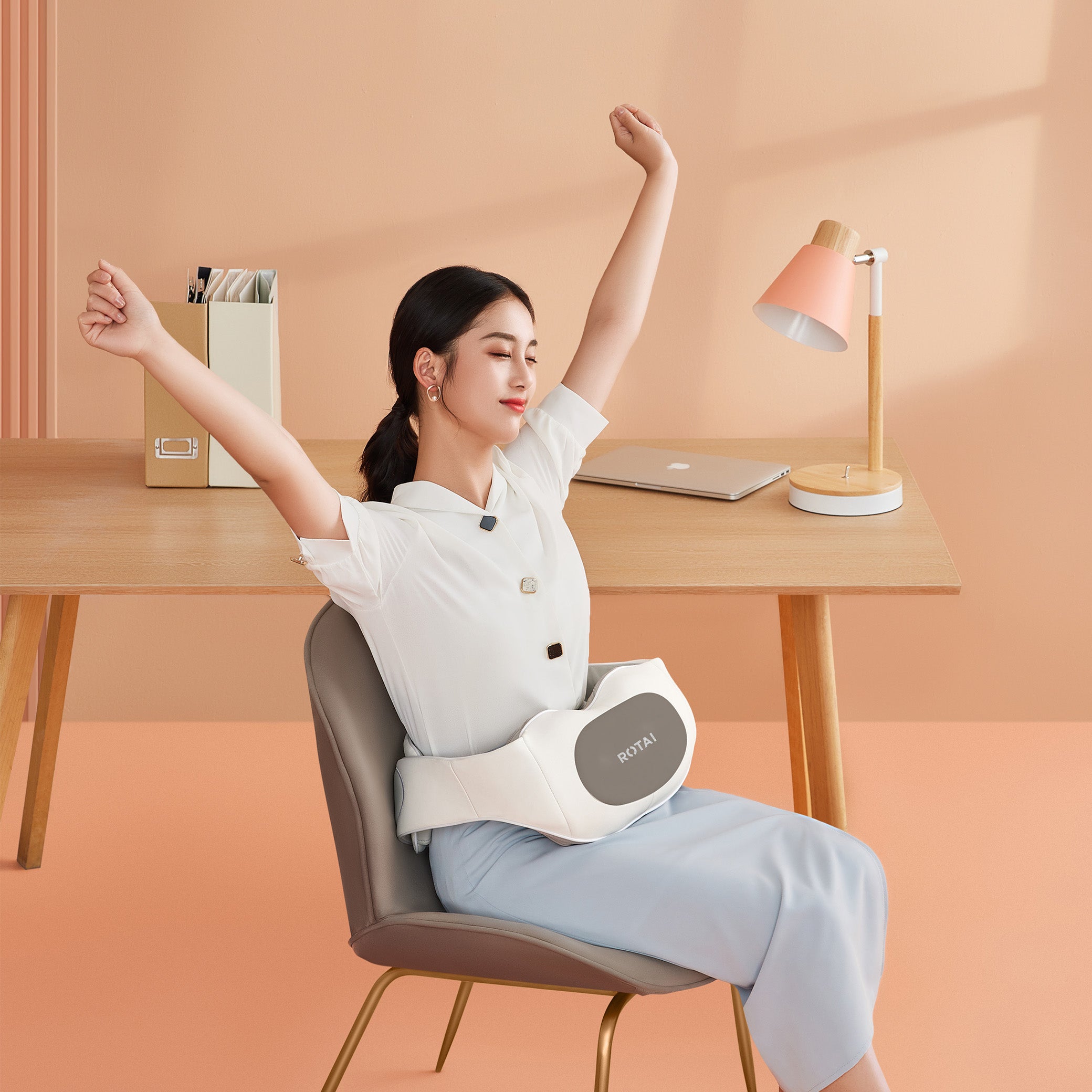 Woman sitting on chair stretching with ROTAI waist massager in modern office space