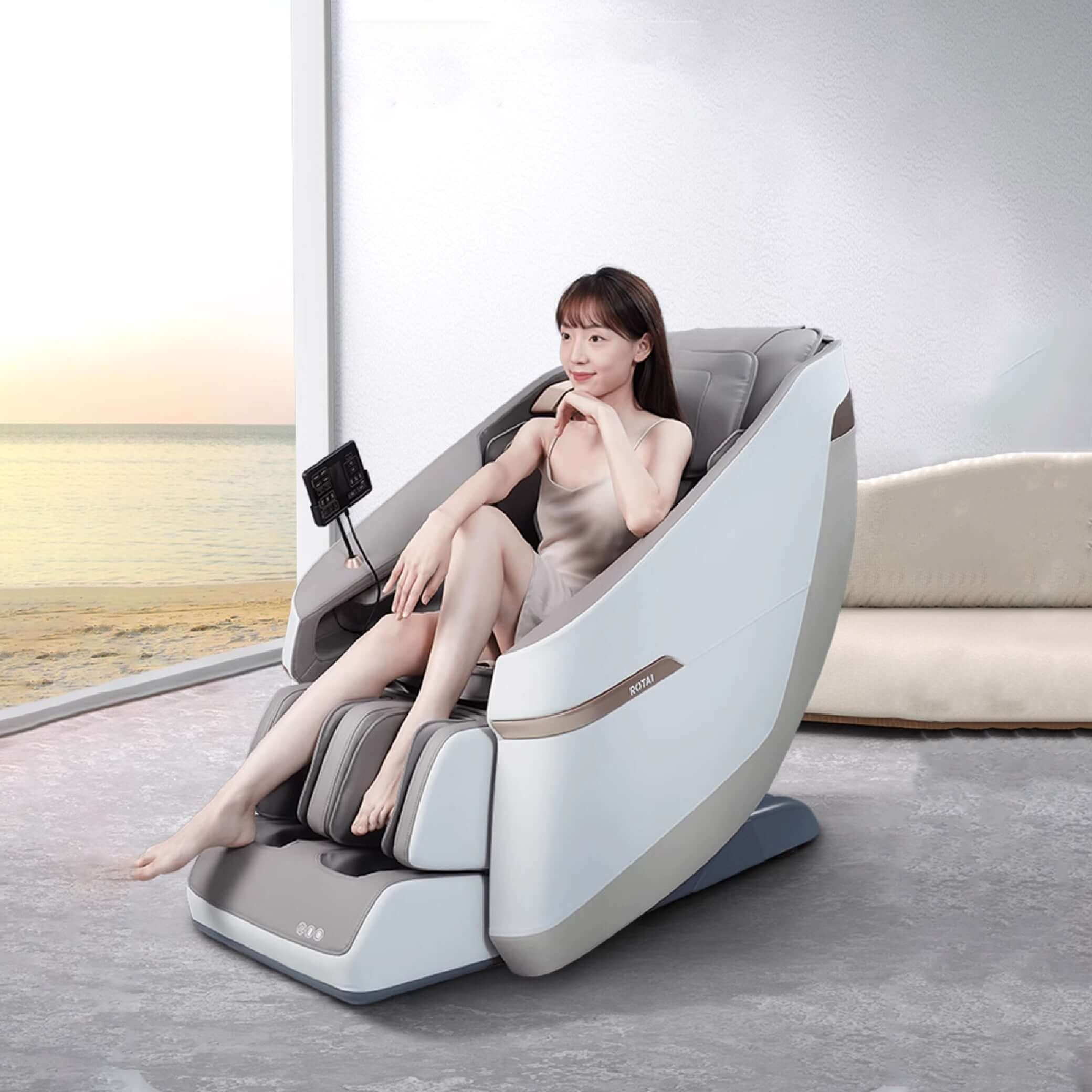 Woman relaxing in a grey Jimny Massage Chair with beach view, featuring 22 wellness programs, foot massage, rocking function, and airbag system , best massage chair uae, massage chair Dubai, massage chair uae, massage chair Saudi Arabia, كرسي التدليك, Bes