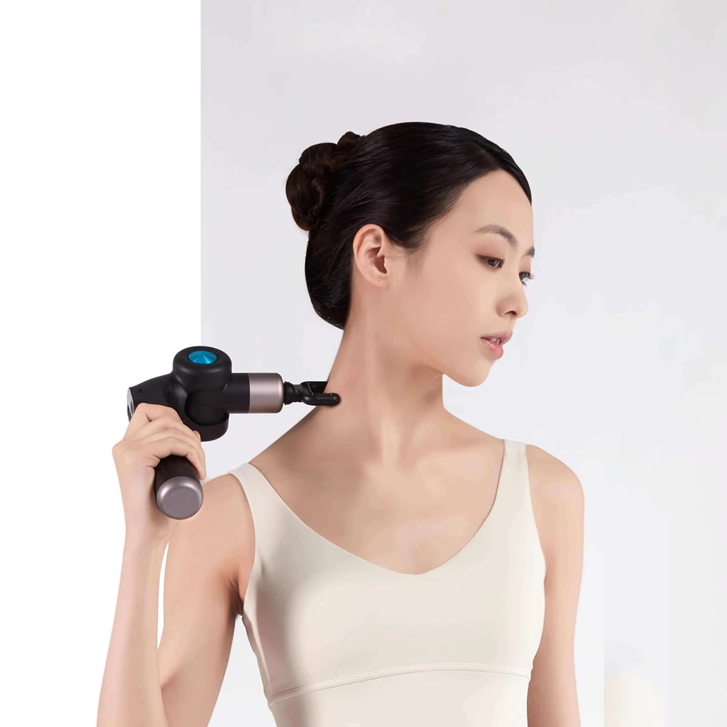 Woman using the Rotai Muscle Therapy Foldable Massage Gun on her neck for muscle relief.